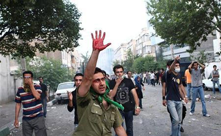 血のついた手を掲げデモに参加する人々