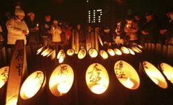 2009/1/17 竹灯籠のろうそくに火をともし、一斉に黙とうする人たち
